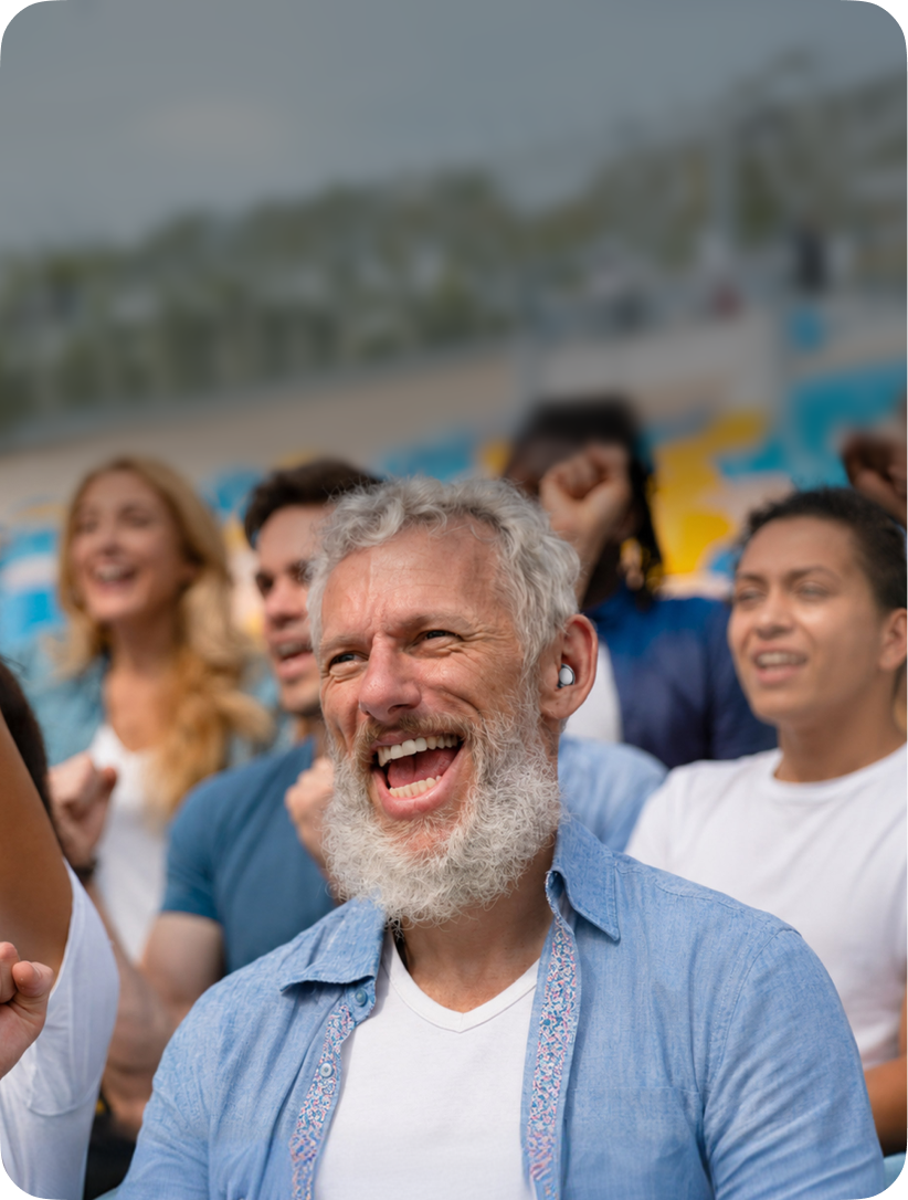 Group of people laughing together outdoors with a blurred background